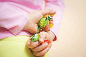 A little girl hiding some candies in her hands.