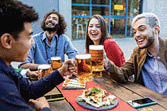 Group of hipster friends enjoying drink at bar terrace