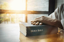 An Asian business man holding a Bible.