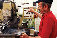 A worker in an industrial company producing parts on his machine.