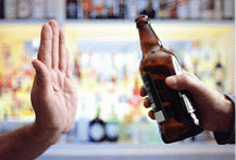 A hand refusing a bottle of beer.